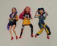 Thumbnail for Three articulated K-Pop Demon Hunter dolls with colorful hairstyles and outfits lying on a plain background.
