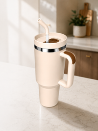 Cream 40oz travel mug with ergonomic handle and reusable straw lid displayed on a modern kitchen countertop, highlighting large-capacity insulated drinkware for daily hydration and convenient at-home use.