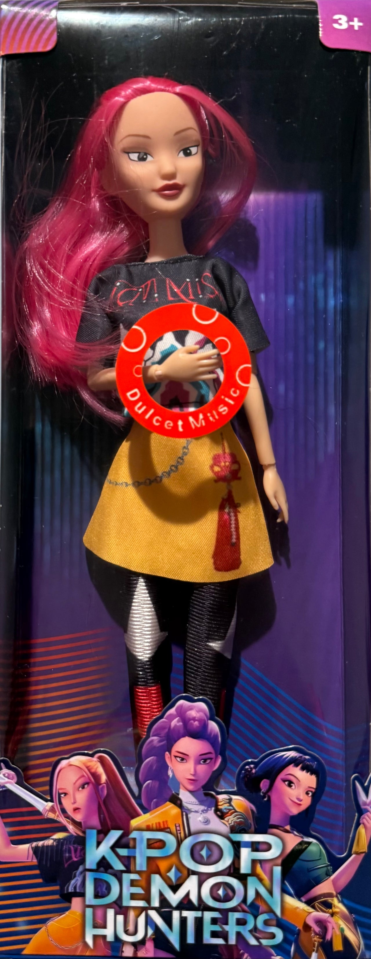 Zoey K-Pop Demon Hunter doll in display-ready packaging with long pink hair, black top, and yellow skirt.