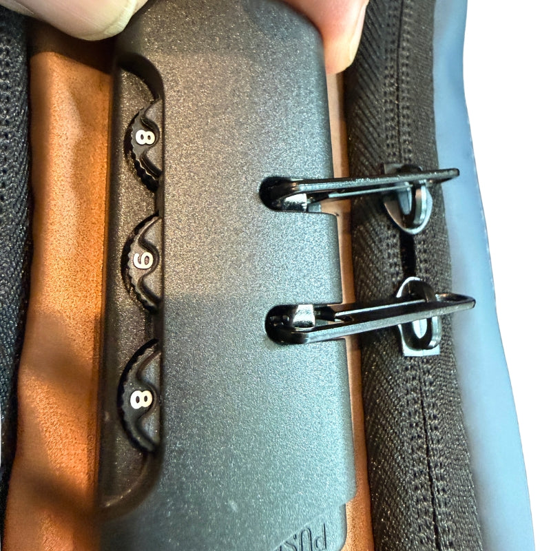 Close-up of anti-theft combination lock and zipper pulls on men's crossbody chest bag