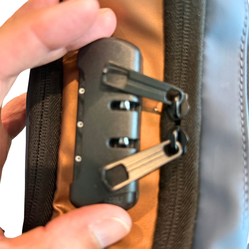 Close-up of anti-theft password lock and zipper pulls on men's crossbody chest bag